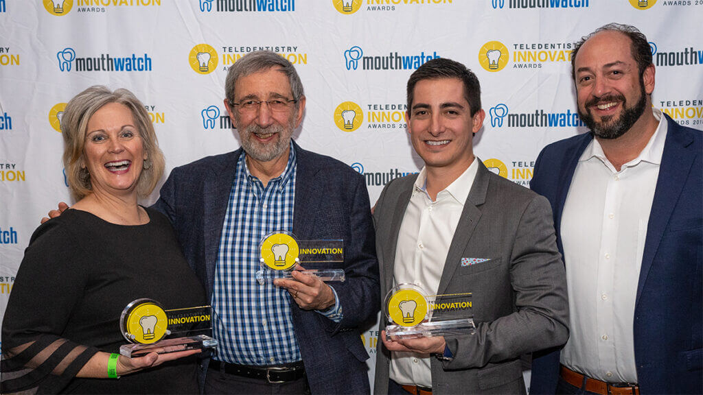 3 award winners holding award trophies