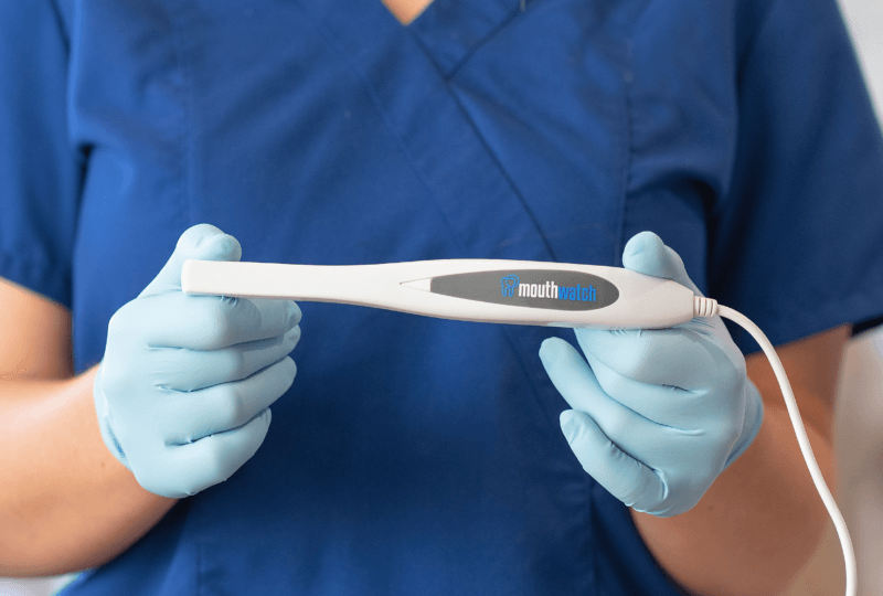 a dental professional holding a MouthWatch Intraoral Camera