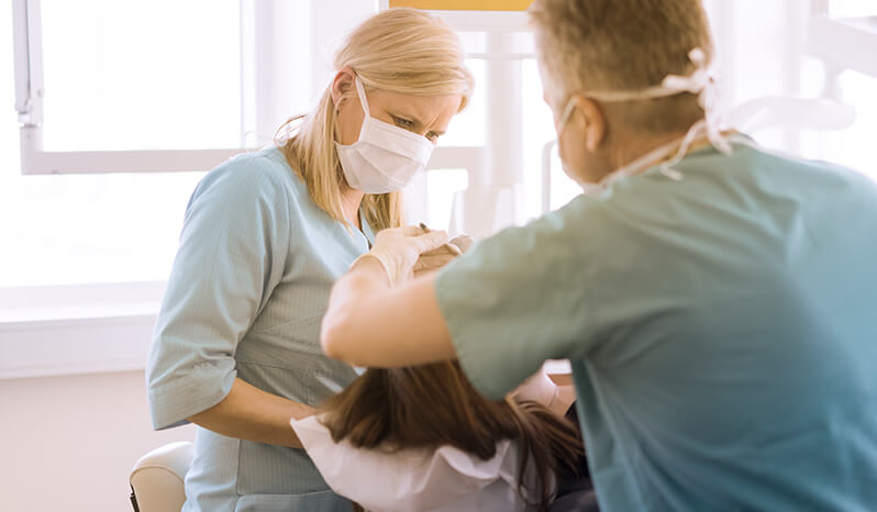 Dentist and assistant working on patient