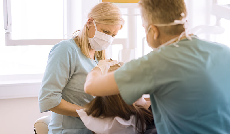 Dentist and Assistant working on patient